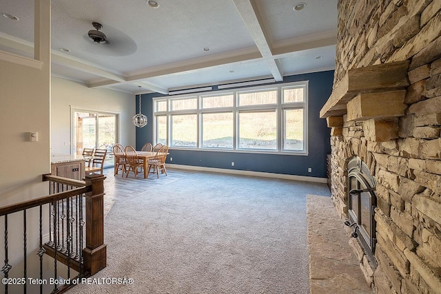 living room with carpet flooring, crown molding, beamed ceiling, coffered ceiling, and a fireplace