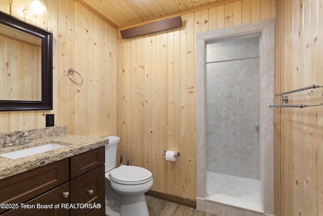 332 N Forest Dr, Star Valley Ranch, WY 83127 - full bathroom with toilet, wood finished floors, wood walls, a shower stall, and vanity