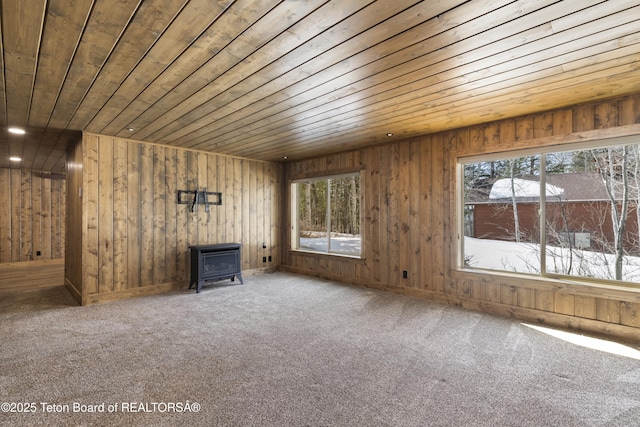 332 N Forest Dr, Star Valley Ranch, WY 83127 - unfurnished living room featuring wood ceiling, carpet floors, and a wood stove