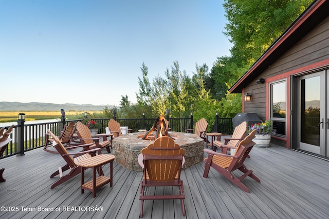 4053 S Adams Rd, Driggs, ID 83422 - wooden deck featuring an outdoor fire pit, a mountain view, and grilling area