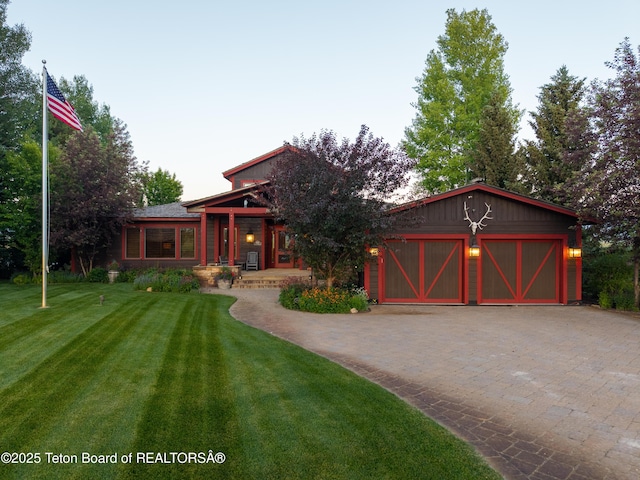 4053 S Adams Rd, Driggs, ID 83422 - view of front of property with an attached garage, decorative driveway, a front lawn, and covered porch
