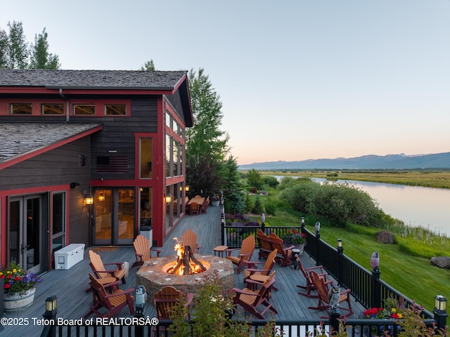 4053 S Adams Rd, Driggs, ID 83422 - deck at dusk with an outdoor fire pit and a water view