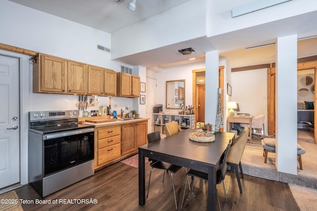 1710 E Porcupine Rd, Jackson, WY 83001 - kitchen with stainless steel electric stove, a sink, dark wood-style flooring, a high ceiling, and light countertops