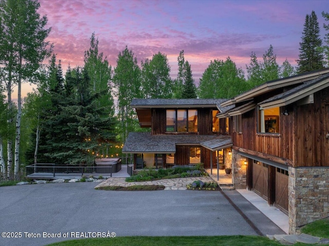 3375 W Killdeer Rd, Jackson, WY 83001 - contemporary house with driveway, a garage, a porch, and stone siding