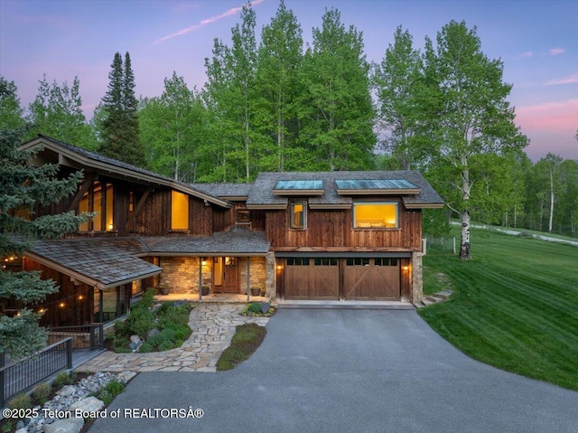 3375 W Killdeer Rd, Jackson, WY 83001 - view of front of home featuring driveway, stone siding, a yard, and a garage