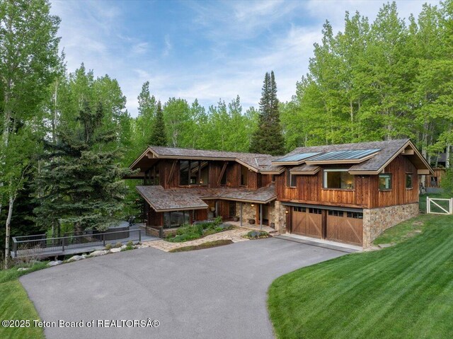 3375 W Killdeer Rd, Jackson, WY 83001 - view of front facade with stone siding, driveway, a garage, and a porch