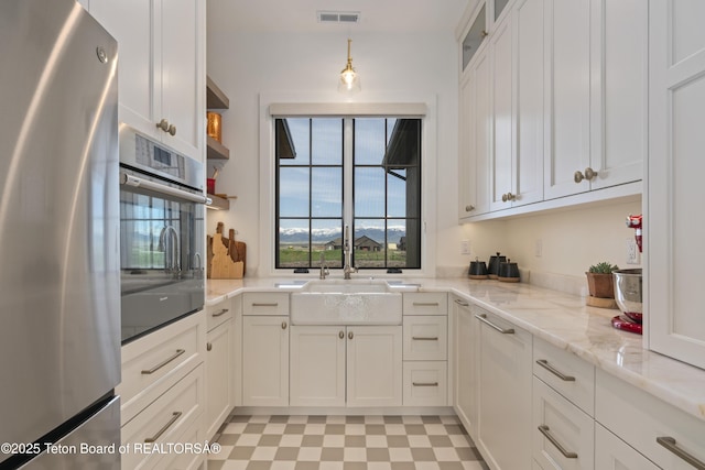 1070 Horseshoe Ln, Driggs, ID 83422 - kitchen with stainless steel appliances, a sink, white cabinets, light stone countertops, and glass insert cabinets