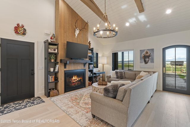 1070 Horseshoe Ln, Driggs, ID 83422 - living room with plenty of natural light, light wood finished floors, a glass covered fireplace, a chandelier, and high vaulted ceiling