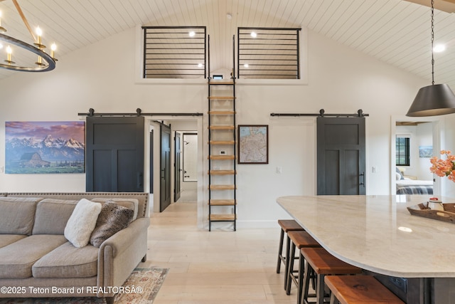1070 Horseshoe Ln, Driggs, ID 83422 - living area with a barn door, high vaulted ceiling, light wood-style flooring, a chandelier, and wooden ceiling