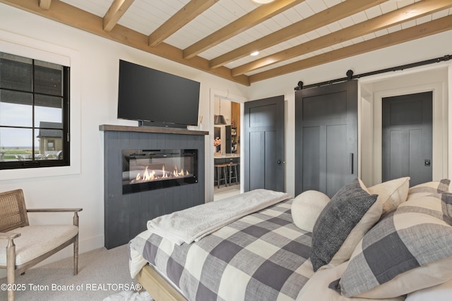 1070 Horseshoe Ln, Driggs, ID 83422 - bedroom featuring carpet, a barn door, beam ceiling, a glass covered fireplace, and baseboards