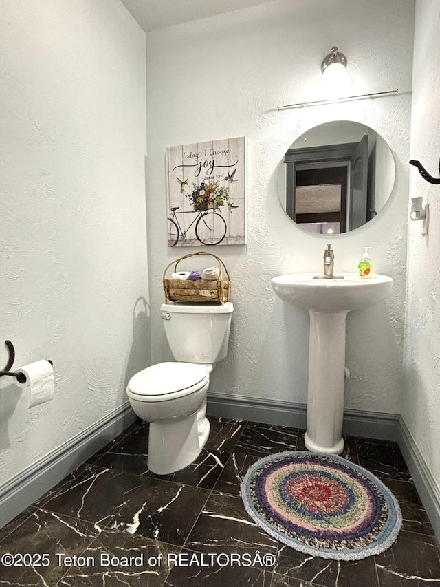 125 Wagon Rut Ln, Auburn, WY 83111 - bathroom with toilet, baseboards, and marble finish floors