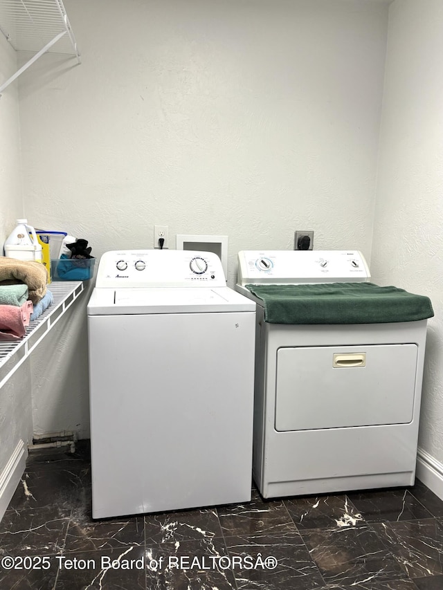 125 Wagon Rut Ln, Auburn, WY 83111 - laundry room with washing machine and dryer, baseboards, dark marble finish flooring, and a textured wall