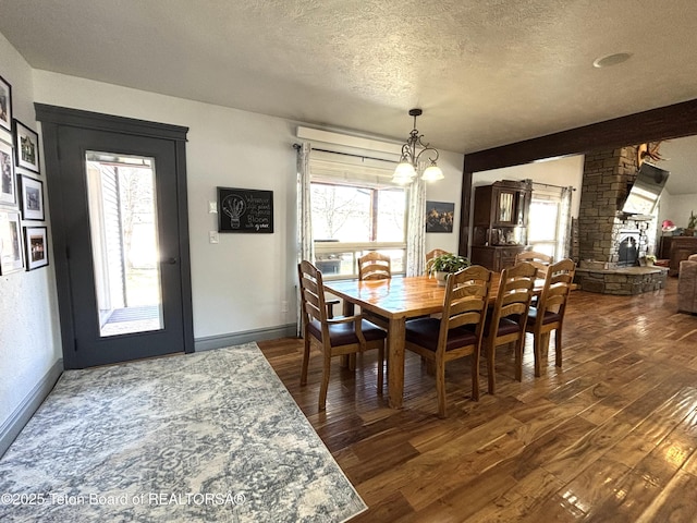 125 Wagon Rut Ln, Auburn, WY 83111 - dining room featuring a textured ceiling, dark wood finished floors, baseboards, and a chandelier