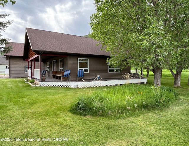125 Wagon Rut Ln, Auburn, WY 83111 - back of property featuring a shingled roof, a yard, and a porch