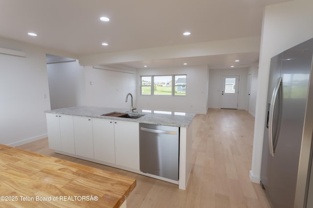 969 Caribou Peak Loop, Etna, WY 83118 - kitchen with stainless steel appliances, white cabinetry, an island with sink, recessed lighting, and light stone counters