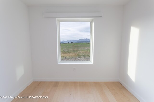 969 Caribou Peak Loop, Etna, WY 83118 - empty room with healthy amount of natural light, light wood-style floors, and a mountain view