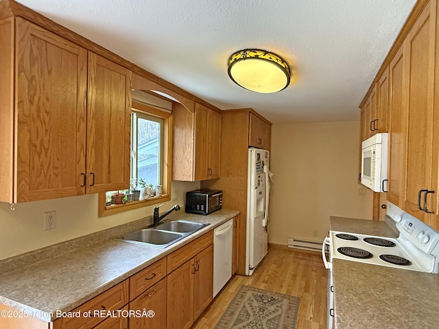 335 E Hansen Ave, Jackson, WY 83001 - kitchen featuring white appliances, light wood finished floors, a sink, baseboard heating, and brown cabinetry