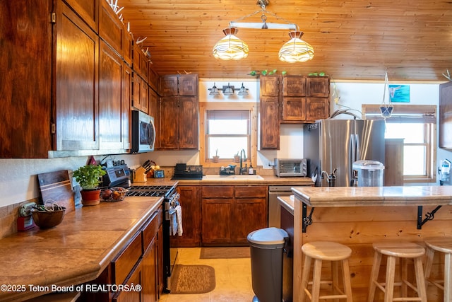 362 Snowmobile Ln, Daniel, WY 83115 - kitchen featuring stainless steel appliances, a kitchen bar, wood ceiling, light countertops, and pendant lighting