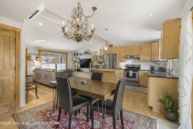 30 Stormy Cir, Jackson, WY 83001 - dining area with light wood-style floors, recessed lighting, vaulted ceiling, a wall mounted air conditioner, and a notable chandelier