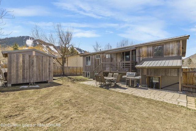 30 Stormy Cir, Jackson, WY 83001 - rear view of house with a patio, a standing seam roof, metal roof, a lawn, and a fenced backyard