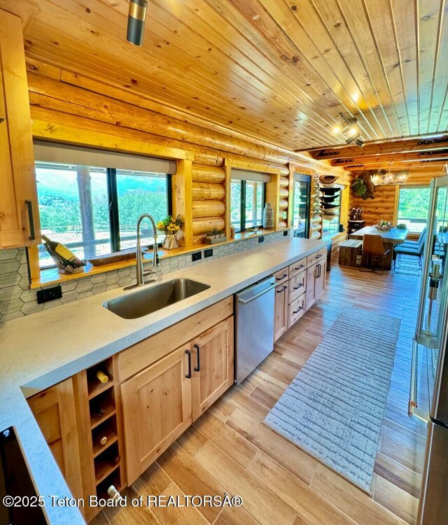 800 Dell Crk, Alpine, WY 83128 - kitchen with rustic walls, a sink, stainless steel dishwasher, light brown cabinets, and wooden ceiling