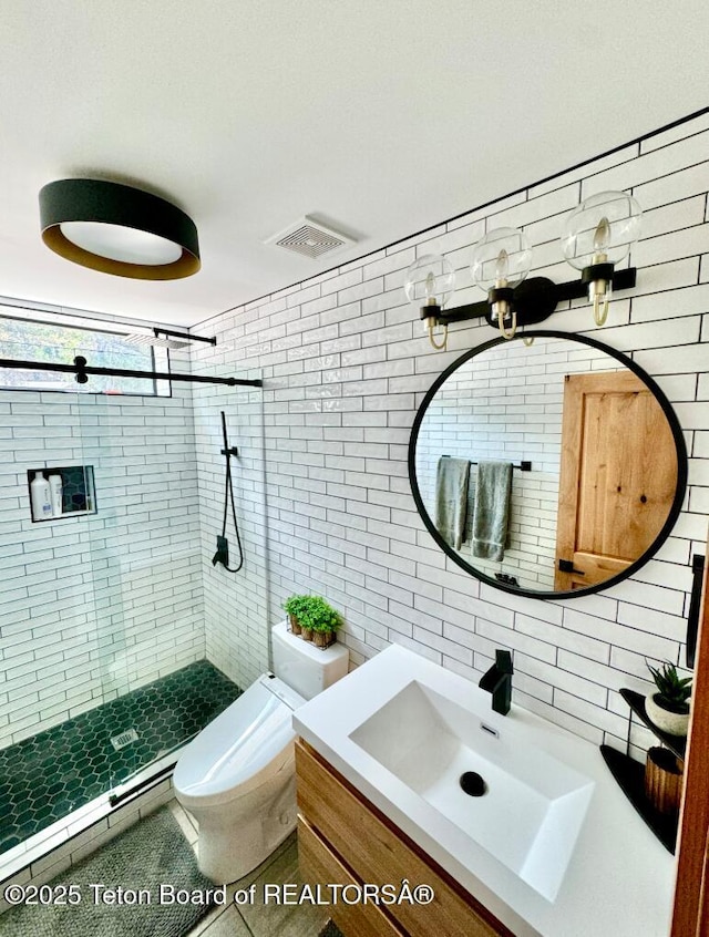 800 Dell Crk, Alpine, WY 83128 - bathroom featuring tile walls, a stall shower, toilet, vanity, and tile patterned flooring
