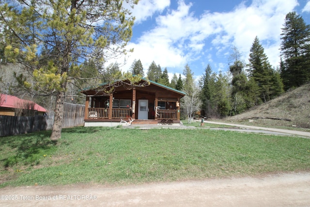 10 Foothill Blvd, Alpine, WY 83128 - cabin with a front yard, a porch, and fence