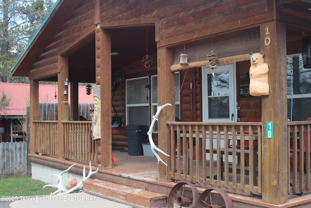 10 Foothill Blvd, Alpine, WY 83128 - property entrance featuring covered porch, log veneer siding, and fence