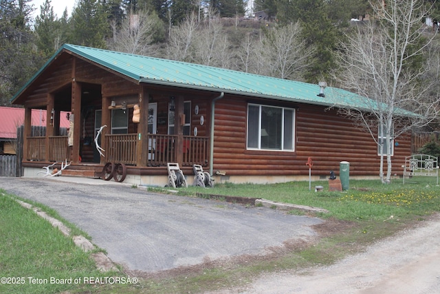 10 Foothill Blvd, Alpine, WY 83128 - view of front of house featuring covered porch, log exterior, and metal roof