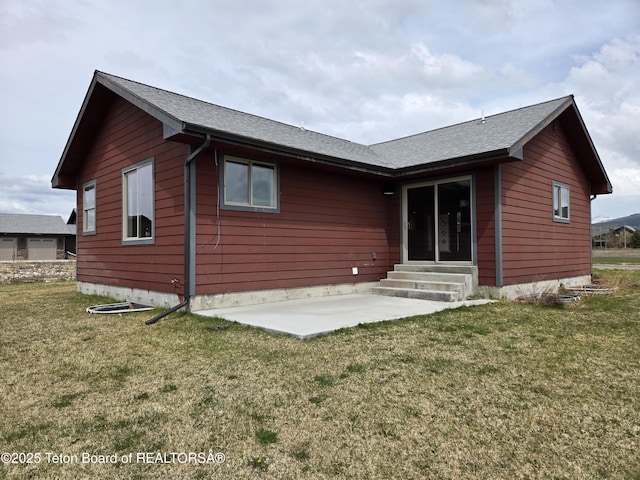 532 Palisade Trl, Driggs, ID 83422 - back of house with entry steps, a patio, a shingled roof, and a lawn