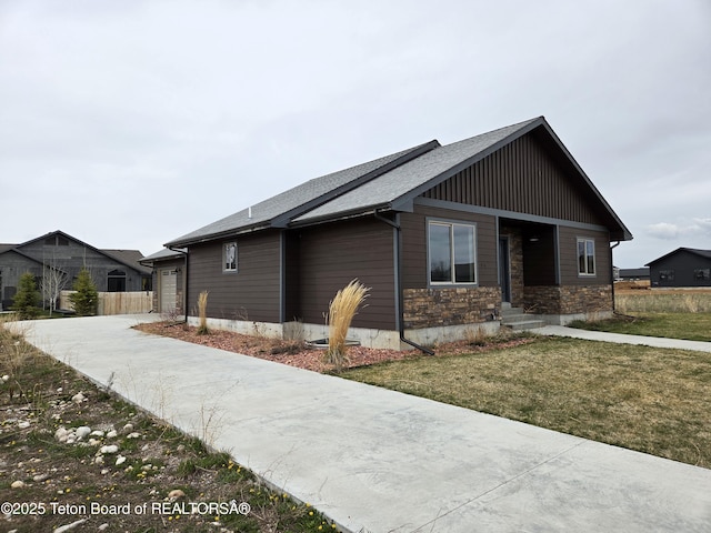 564 Palisade Trl, Driggs, ID 83422 - view of front of property featuring a front lawn, roof with shingles, driveway, and stone siding