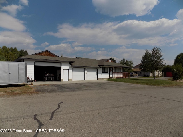 811 Jade St, Pinedale, WY 82941 - ranch-style house featuring a garage, asphalt driveway, and covered porch
