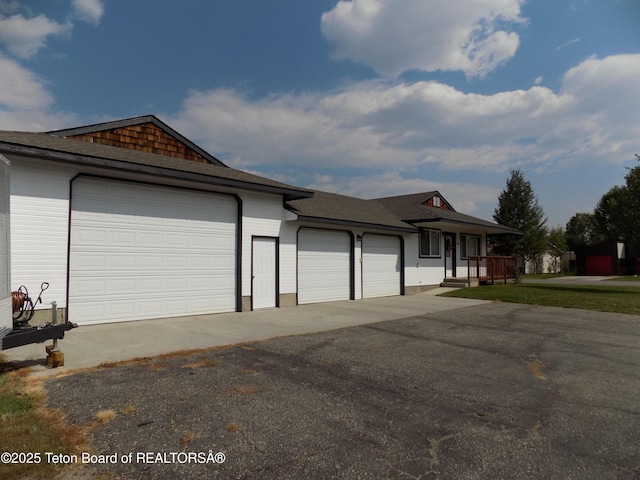 811 Jade St, Pinedale, WY 82941 - view of front of property featuring a garage, asphalt driveway, and a shingled roof