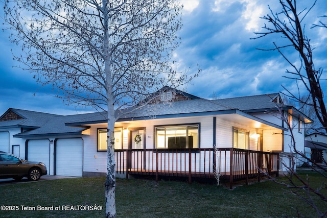 811 Jade St, Pinedale, WY 82941 - view of front of property featuring roof with shingles, a garage, a front yard, and a porch