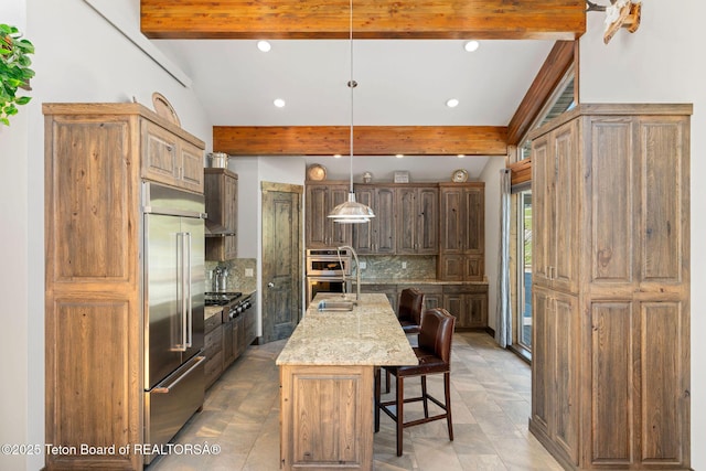 kitchen featuring beamed ceiling, appliances with stainless steel finishes, decorative backsplash, and a breakfast bar