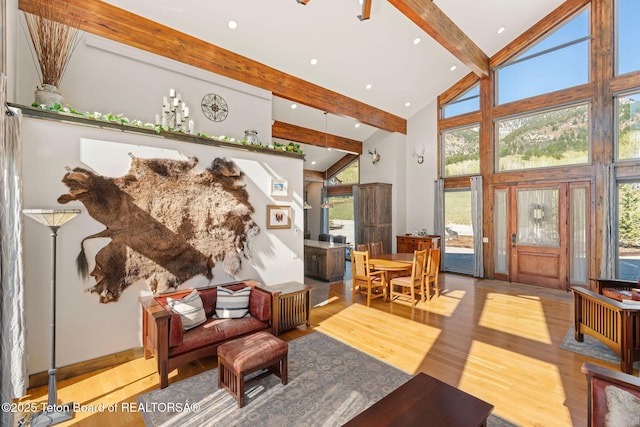 living room with beam ceiling, high vaulted ceiling, plenty of natural light, and wood finished floors