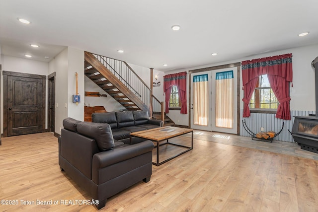living area with a wood stove, stairway, wood finished floors, and recessed lighting