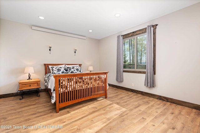 bedroom with baseboards, light wood finished floors, and recessed lighting