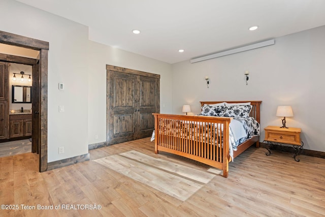 bedroom featuring ensuite bathroom, wood finished floors, baseboards, and recessed lighting
