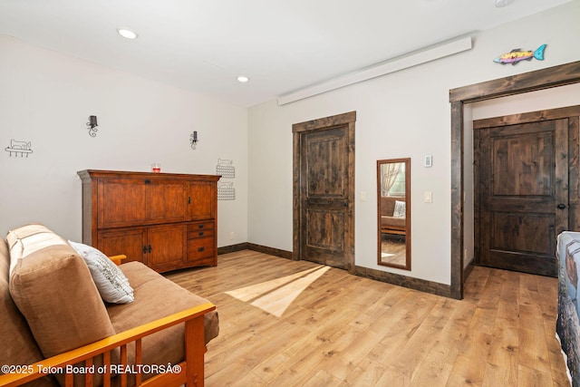 living area with baseboards, light wood finished floors, and recessed lighting