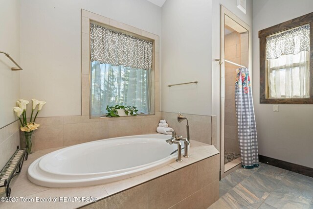 bathroom with baseboards, a shower stall, and a bath