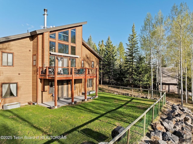rear view of property with a lawn, fence, and a wooden deck