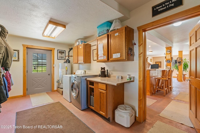 86 Hawks Rest Rd, Etna, WY 83118 - washroom with washing machine and clothes dryer, water heater, cabinet space, a textured ceiling, and light colored carpet