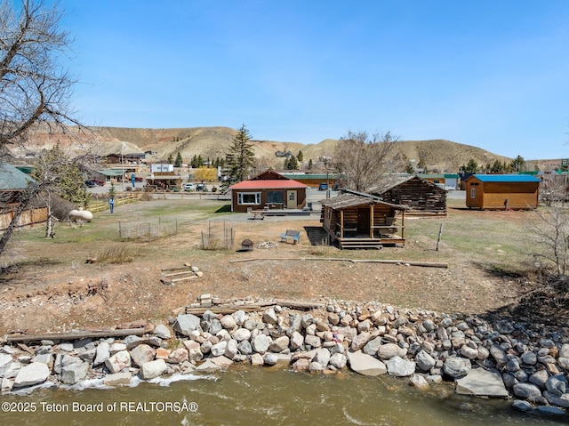 611 W Ramshorn St, Dubois, WY 82513 - back of house featuring a mountain view, fence, an outdoor structure, and exterior structure