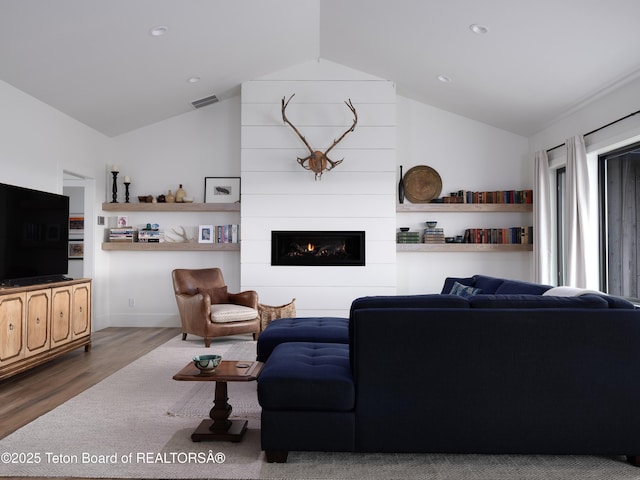 living area featuring a fireplace, recessed lighting, wood finished floors, lofted ceiling, and visible vents