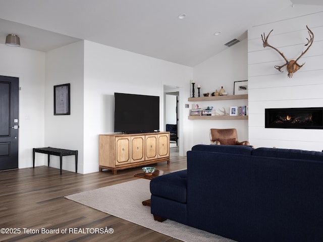 living room featuring visible vents, lofted ceiling, wood finished floors, recessed lighting, and a large fireplace