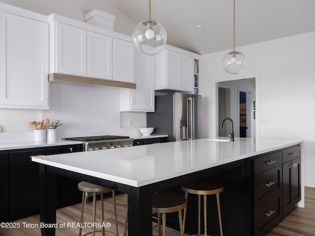 kitchen featuring high end fridge, a sink, white cabinetry, and light countertops