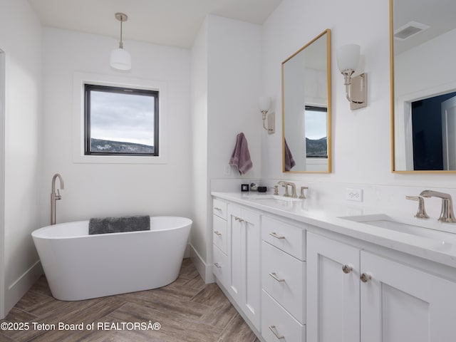 bathroom with visible vents, a sink, and a wealth of natural light