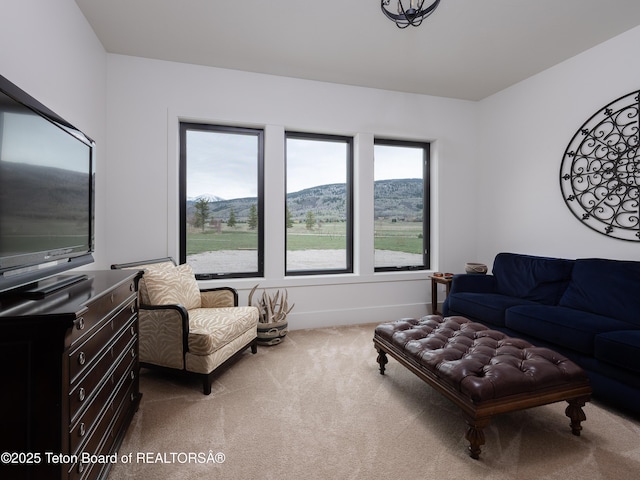 living area featuring baseboards, carpet, and a mountain view