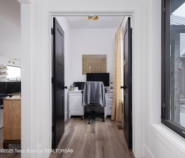 office area with a sink, visible vents, and wood finished floors